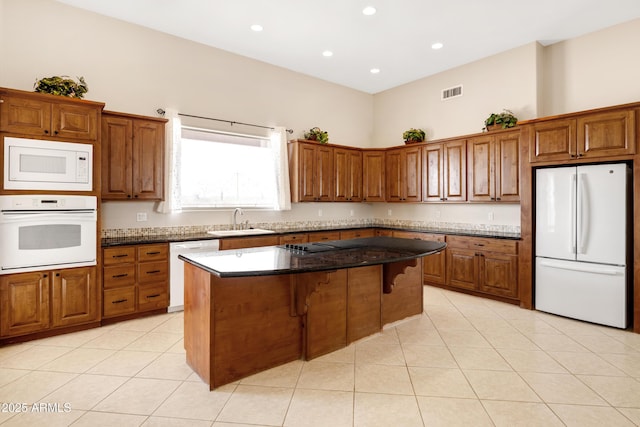 11266 W Calle Con Queso, Casa Grande, AZ 85194 - kitchen featuring white appliances, a sink, a center island, brown cabinets, and light tile patterned floors