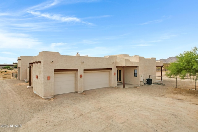 11266 W Calle Con Queso, Casa Grande, AZ 85194 - view of front facade with an attached garage, central AC, stucco siding, and dirt driveway