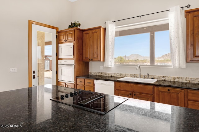 11266 W Calle Con Queso, Casa Grande, AZ 85194 - kitchen with white appliances, a sink, brown cabinetry, and dark stone countertops