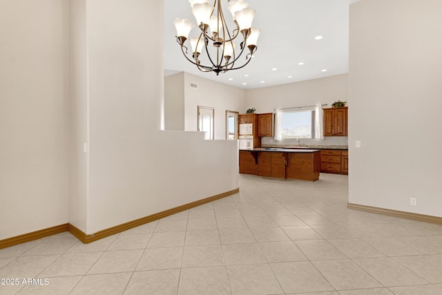 11266 W Calle Con Queso, Casa Grande, AZ 85194 - kitchen featuring brown cabinets, white appliances, a chandelier, a sink, and a breakfast bar area