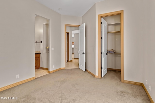11266 W Calle Con Queso, Casa Grande, AZ 85194 - unfurnished bedroom featuring light carpet, a walk in closet, baseboards, and ensuite bath