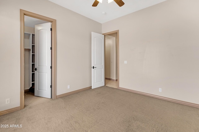 11266 W Calle Con Queso, Casa Grande, AZ 85194 - unfurnished bedroom with a walk in closet, carpet floors, baseboards, and ceiling fan