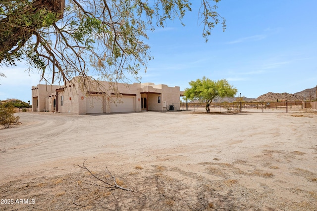11266 W Calle Con Queso, Casa Grande, AZ 85194 - view of yard with an attached garage, a mountain view, and dirt driveway