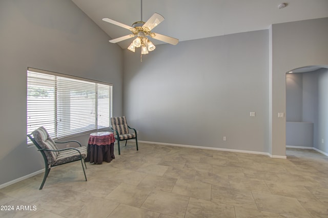 living area with ceiling fan and high vaulted ceiling