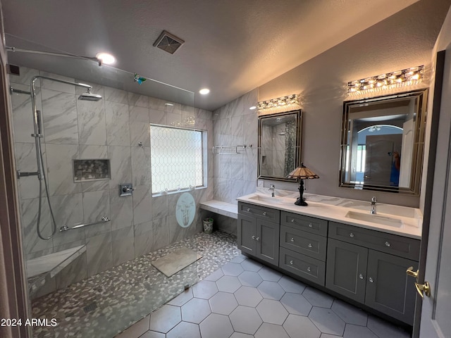 bathroom featuring vanity, lofted ceiling, tile patterned flooring, a textured ceiling, and tiled shower