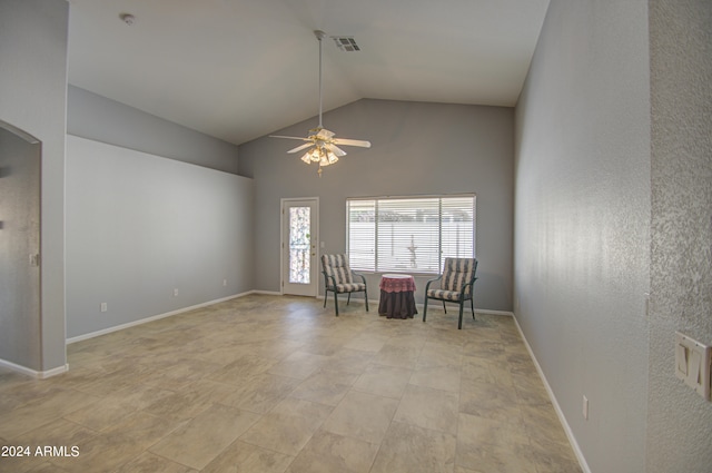 unfurnished room with ceiling fan and high vaulted ceiling