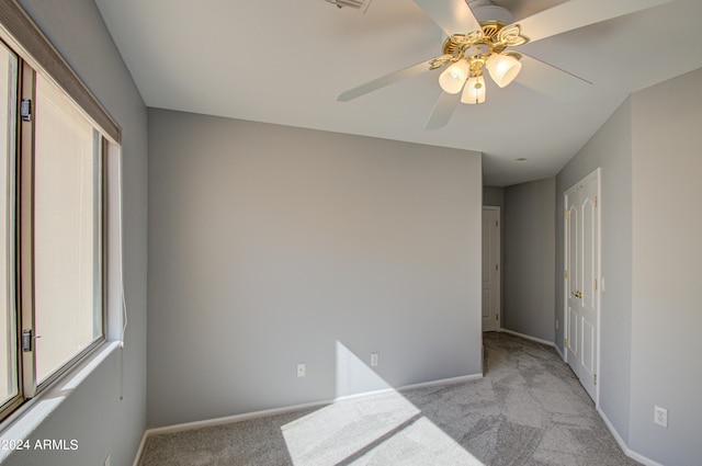 unfurnished bedroom featuring light colored carpet and ceiling fan