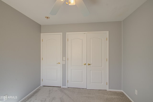 unfurnished bedroom featuring ceiling fan and light colored carpet