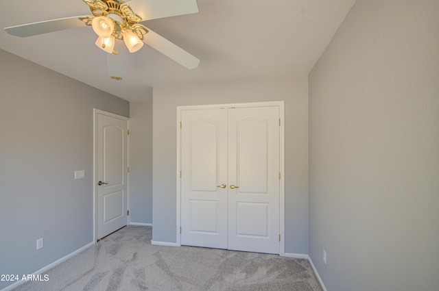 unfurnished bedroom with ceiling fan, a closet, and light colored carpet