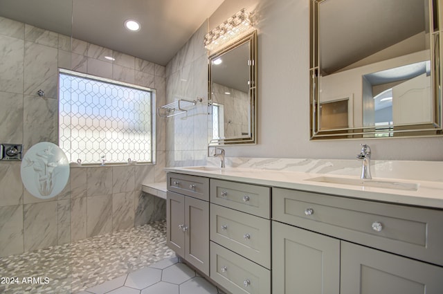 bathroom featuring a tile shower, vanity, tile patterned floors, and lofted ceiling