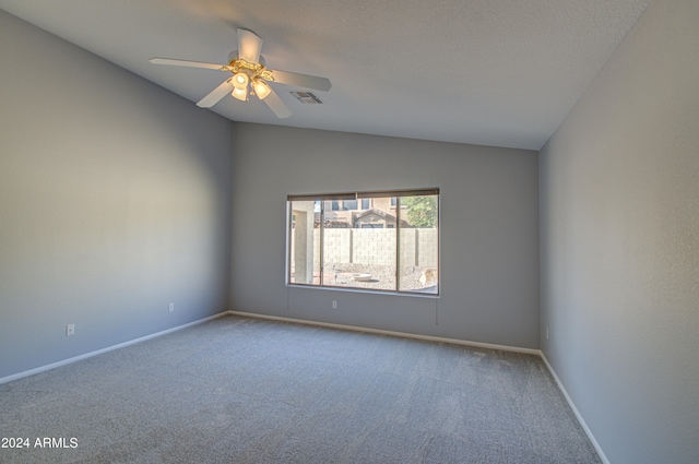 empty room featuring ceiling fan, carpet floors, and vaulted ceiling