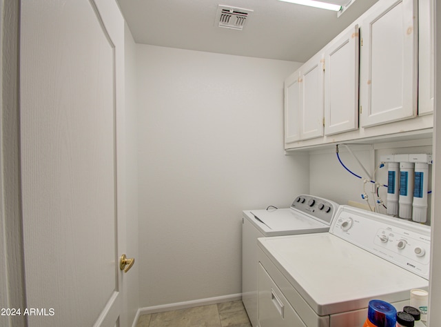 laundry area featuring cabinets, light tile patterned floors, and separate washer and dryer