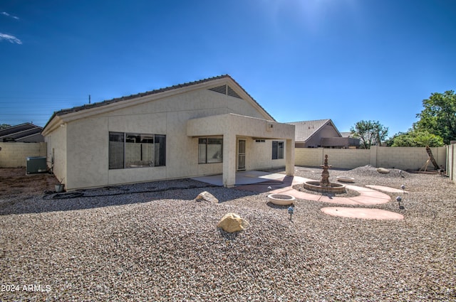 rear view of house with central air condition unit and a patio area