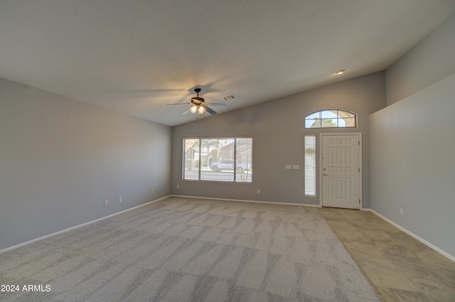 carpeted foyer entrance with ceiling fan and lofted ceiling