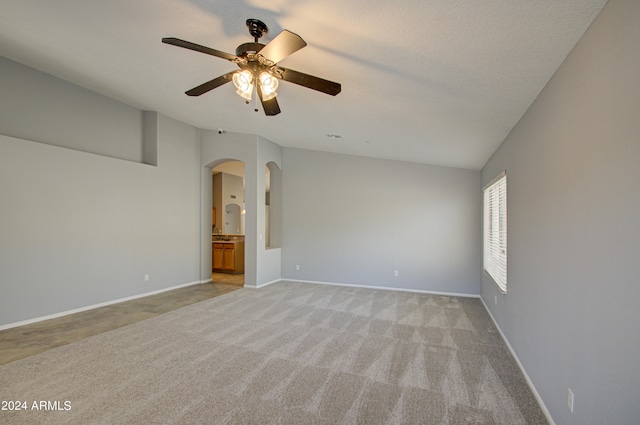 carpeted spare room featuring a textured ceiling and ceiling fan