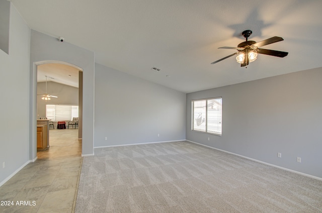 unfurnished room featuring ceiling fan, light colored carpet, and lofted ceiling