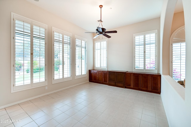 spare room featuring light tile patterned floors, baseboards, and a ceiling fan