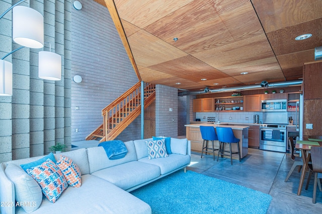 living area featuring stairs and wooden ceiling