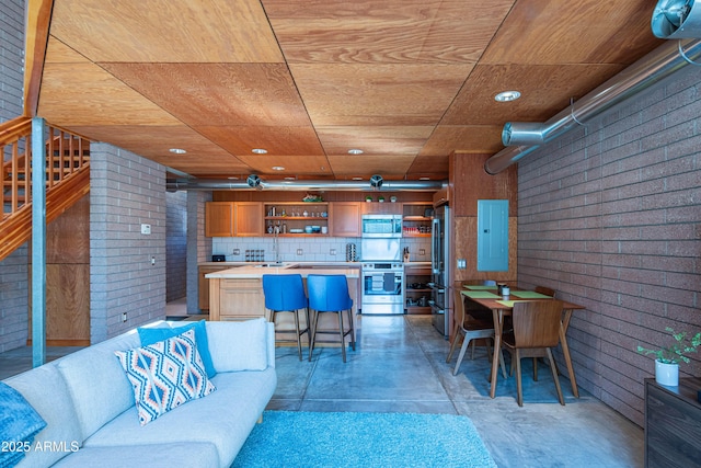 living room with electric panel, stairway, wooden ceiling, and brick wall