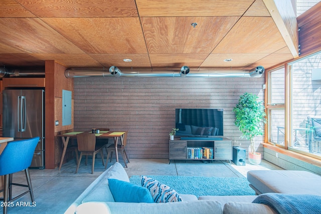 living area featuring electric panel, wood ceiling, and concrete floors