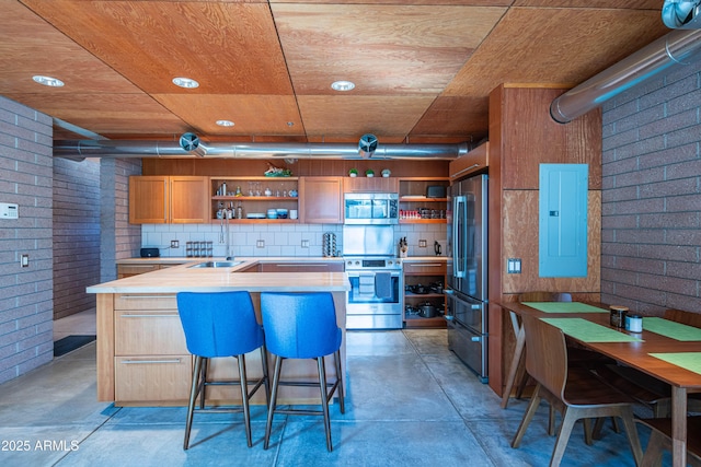 kitchen featuring open shelves, electric panel, appliances with stainless steel finishes, and finished concrete floors