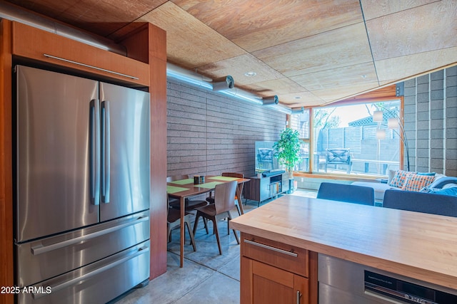 kitchen with wine cooler, concrete floors, butcher block counters, and freestanding refrigerator