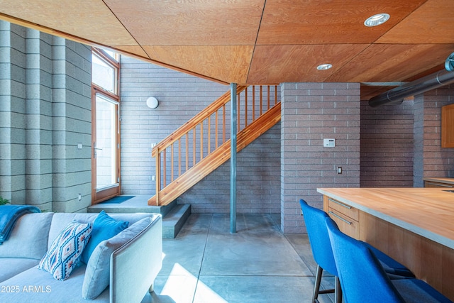 basement with stairway and brick wall