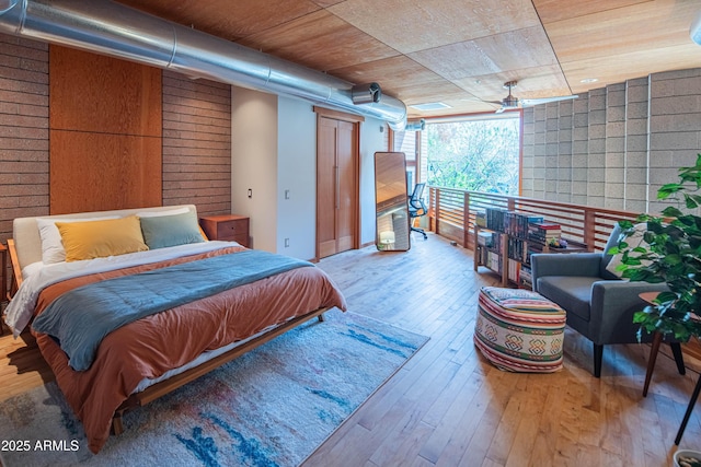 bedroom with hardwood / wood-style floors and wood ceiling