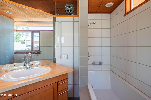 bathroom featuring bathing tub / shower combination, tile walls, and vanity