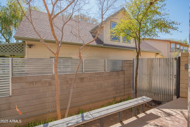 view of property exterior with fence and roof with shingles