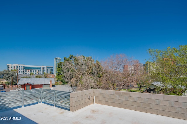 view of patio / terrace with a city view and fence