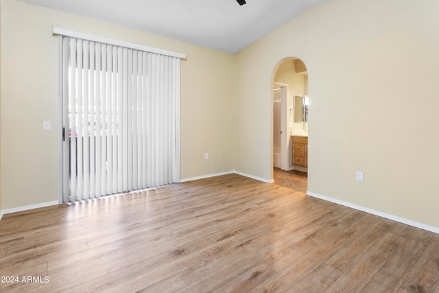 unfurnished room with light wood-type flooring, lofted ceiling, and ceiling fan