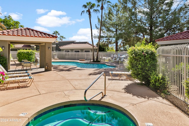 view of swimming pool with a hot tub and a patio area