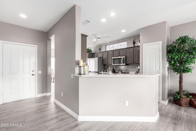 kitchen with ceiling fan, stainless steel appliances, kitchen peninsula, and light hardwood / wood-style flooring