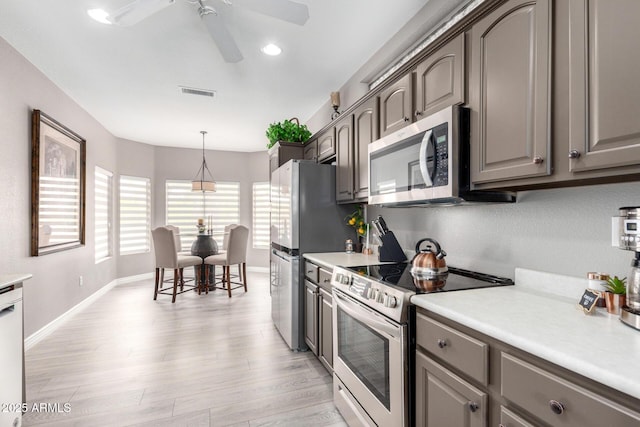 kitchen with hanging light fixtures, light hardwood / wood-style flooring, ceiling fan, and appliances with stainless steel finishes