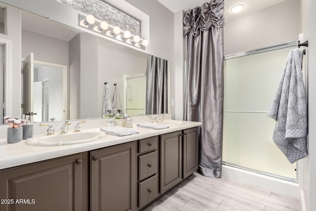 bathroom featuring vanity, hardwood / wood-style flooring, and a shower with shower door