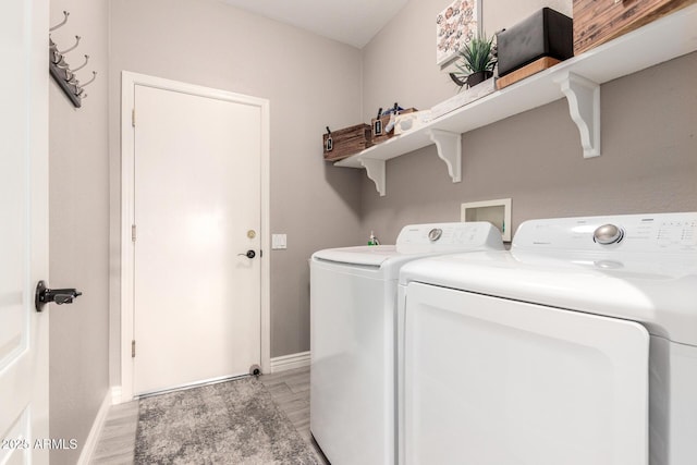 clothes washing area with washer and clothes dryer and light hardwood / wood-style floors