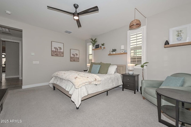 bedroom with ceiling fan, light colored carpet, and multiple windows