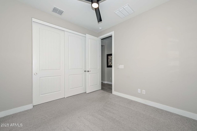 unfurnished bedroom featuring a closet, ceiling fan, and light colored carpet