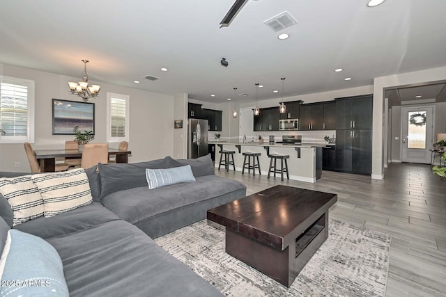 living room with ceiling fan with notable chandelier and a healthy amount of sunlight