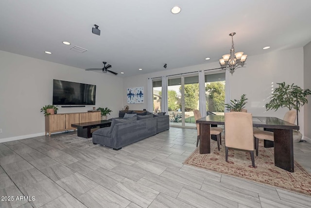 living room featuring ceiling fan with notable chandelier