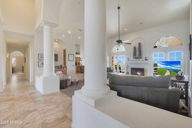 living room featuring ceiling fan and a high ceiling