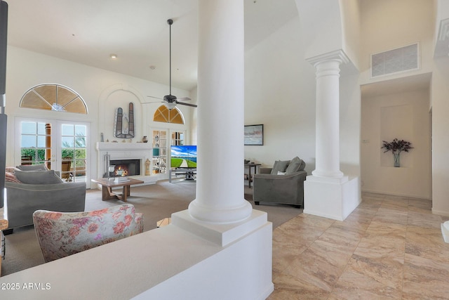 living room featuring ceiling fan and a high ceiling