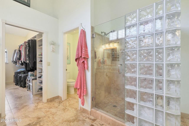 bathroom with toilet and a shower with shower door