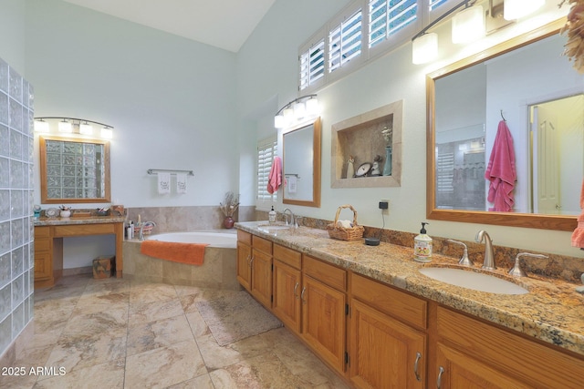 bathroom with vanity, a wealth of natural light, and tiled tub