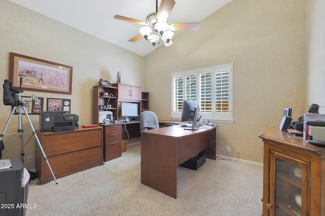 home office featuring light carpet, vaulted ceiling, and ceiling fan