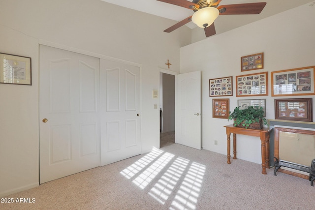 interior space featuring a closet, light colored carpet, and ceiling fan