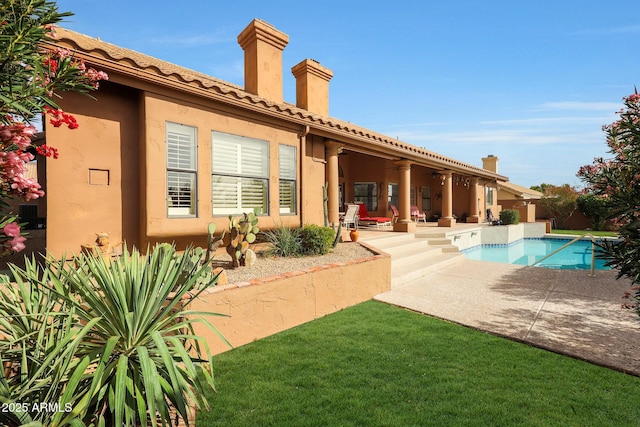 back of property with ceiling fan and a patio