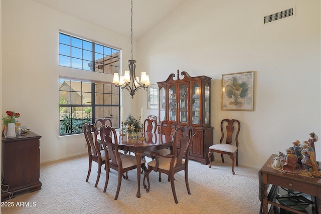 dining space with light carpet, a high ceiling, and a notable chandelier