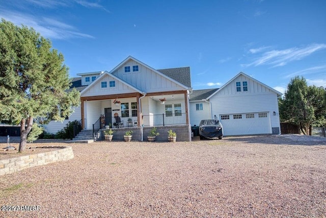 craftsman house with board and batten siding, covered porch, driveway, and a garage